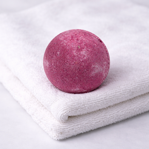 Pink bath bomb on a white towel