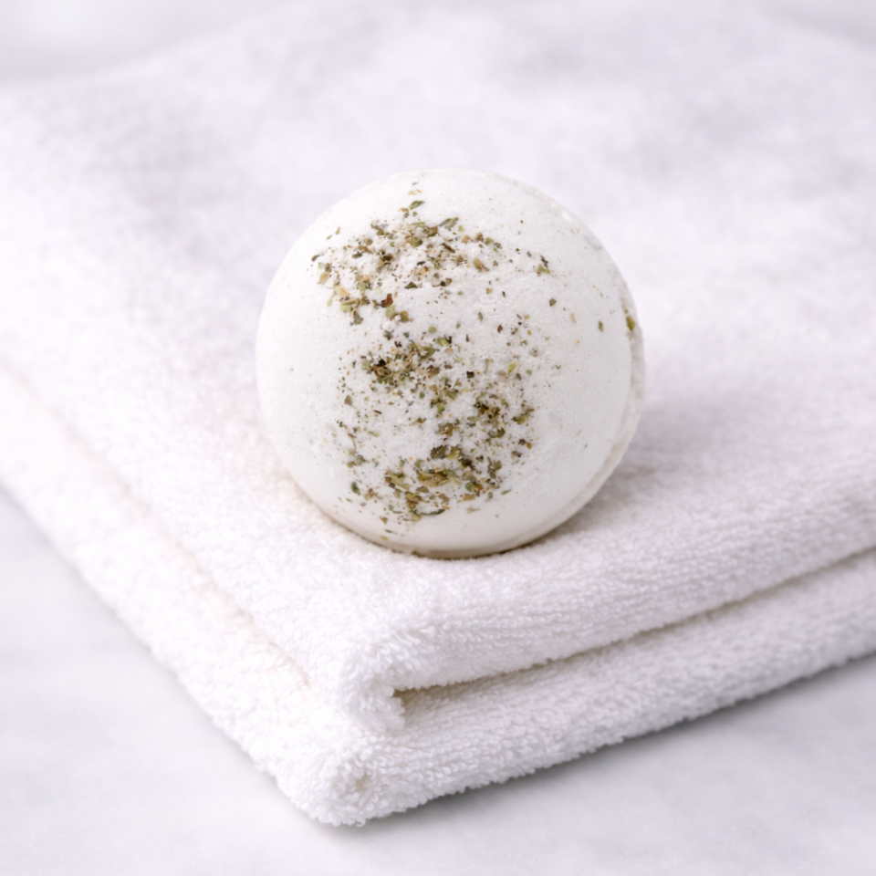White bath bomb with green flecks on a white towel