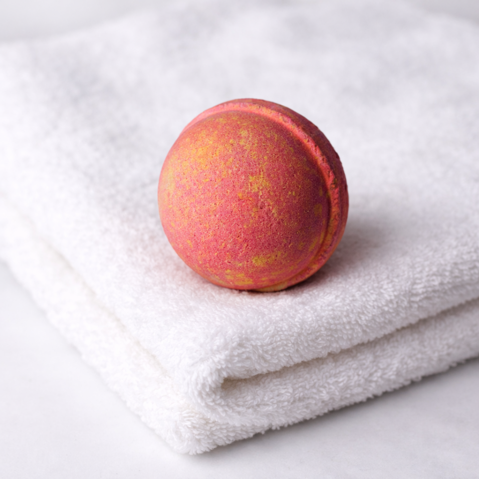 Red and yellow bath bomb on a white towel