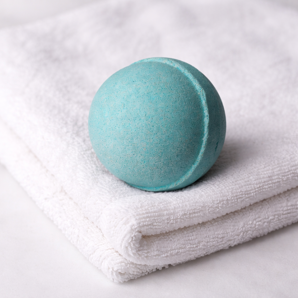 Turquoise bath bomb on a white towel